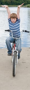 Boy on a bicycle with river at background