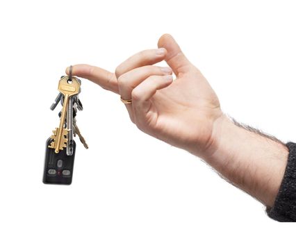 man's hand holds bunch of keys and car remote, hanging on keyring. isolated on white