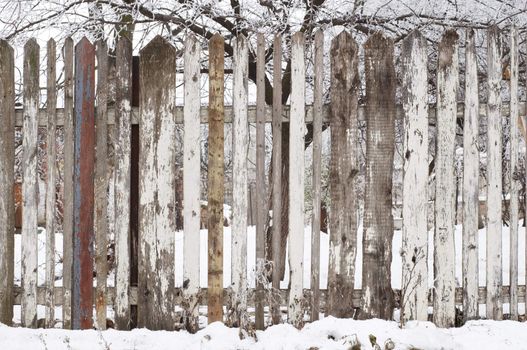 stain wooden fence at snowy winter, background.