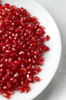 pomegranate seeds on the plate, half view from the top