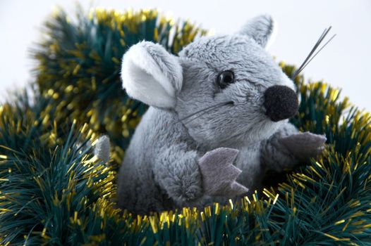 The grey toy mouse sitting in a tinsel