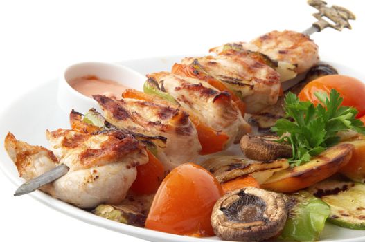 chicken kebab with grilled vegetables on white plate, selective focus