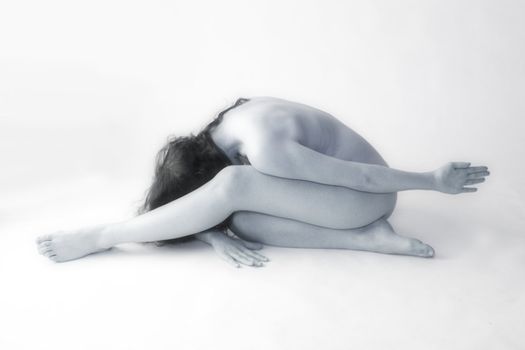 Studio portrait of a naked beauty model folded up
