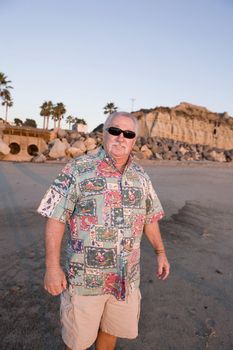 Senior Man enjoying the Beach wearing a Christmas Hawaiian shirt at Sunset in San Clemente California.