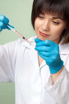 brunette doctor in white smock filling the insuline syringe.