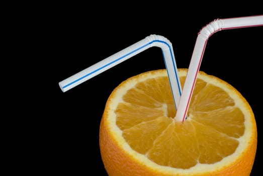 a ripe orange and two drinking straws