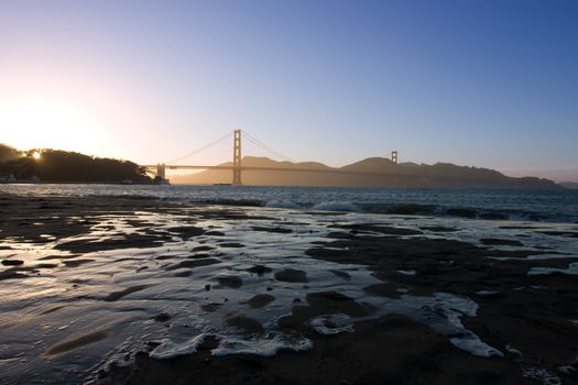 Golden Gate at the dusk with water on sand