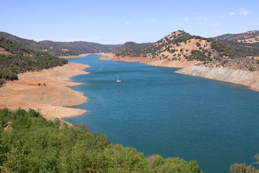 Small boat flowing on the blue river