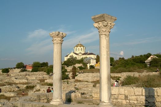 Ancient Greek columns on a background of an orthodox temple in Chersonesos                              