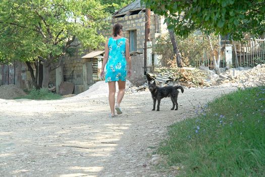 The girl and dog on a background of the rural house                               