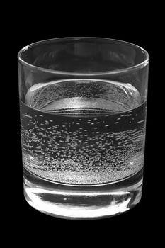 Glass with pure water on a black background