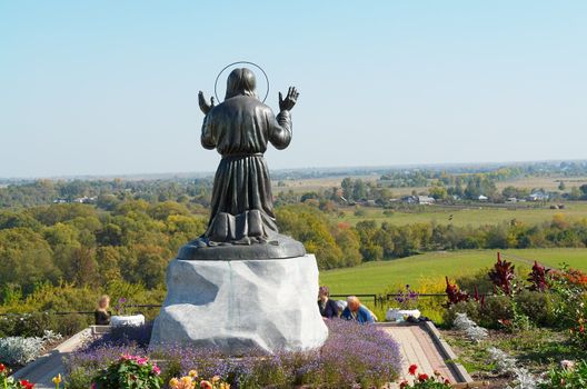 Statue of the eremite which prays on a hum noise of the blue sky