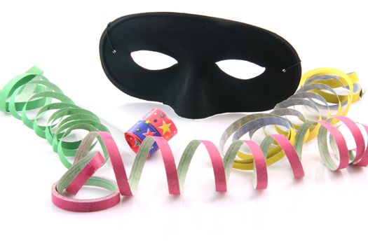 holidays and party time paper streamers party blower and black mask isolated on white background