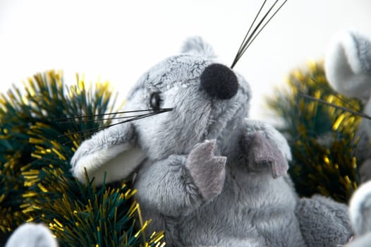 The grey toy mouse sitting in a tinsel