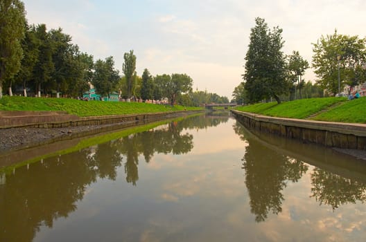 The cloudy sky is reflected in the river