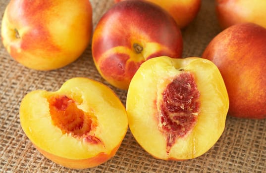 Bunch of ripe nectarine peaches on mesh background