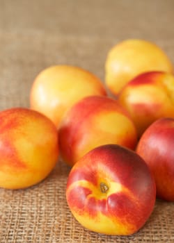 Bunch of ripe nectarine peaches on mesh background