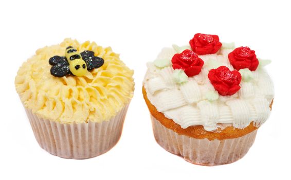 Variety of vanilla cupcakes with various decorations on white background