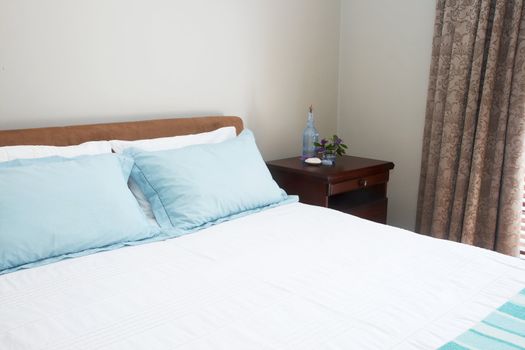 Beautiful bedroom interior with white sheets and striped towels 