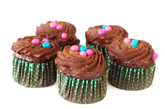 Miniature decorated chocolate cupcakes on white background