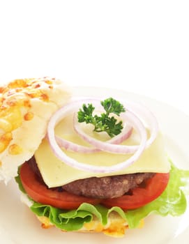 Tasty hamburger with grilled patty, tomato, cheese and lettuce on white cheese bun