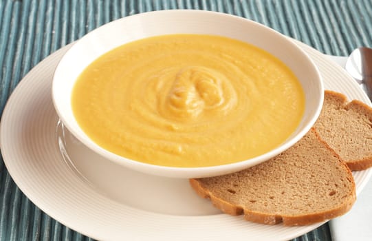 Bowl of fresh hot butternut soup served with rye berliner bread