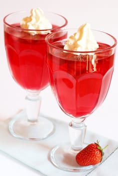 Strawberry jelly with fresh strawberry and cream in tall glass on white background