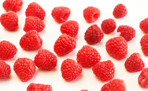 Fresh raspberries scattered on white background