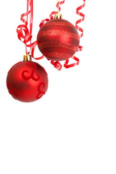 Two red Christmas baubles hanging on ribbons isolated on white background with copy space. 