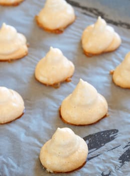 Freshly baked meringue cookies on a baking tray