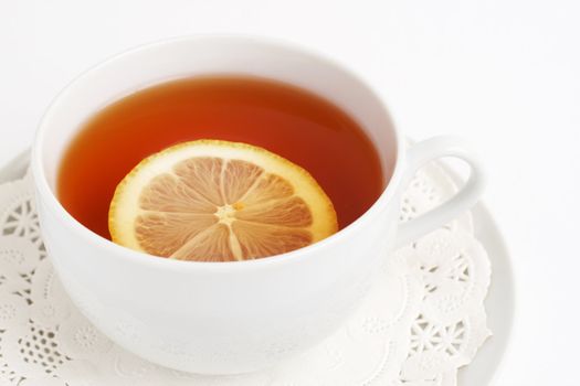 Cup of tea with lemon on white background