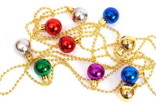 Colorful Christmas baubles on a gold string on white background with copy space. 