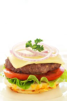 Tasty hamburgers with grilled patty, tomato, cheese, onion and lettuce on white background
