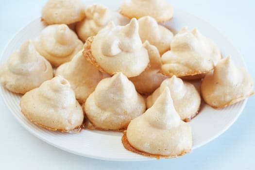 Freshly baked meringue cookies on a white plate