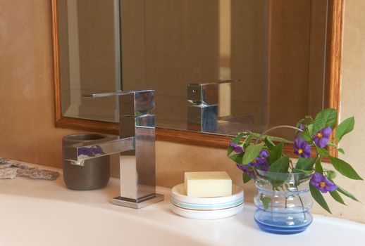 Beautiful sink in a bathroom with natural soap and flowers