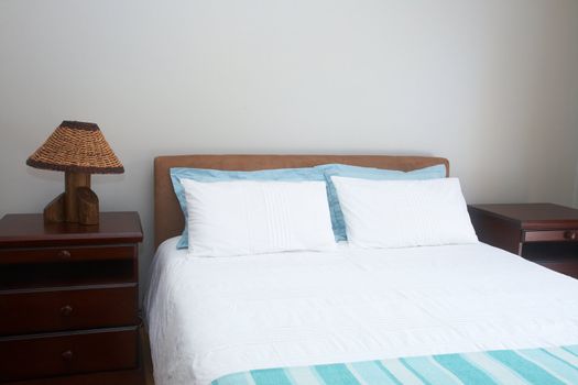 Beautiful bedroom interior with white sheets and bedside tables