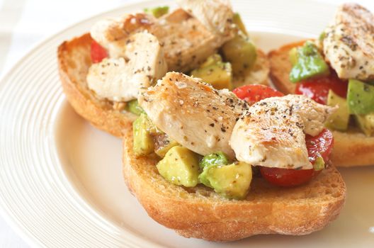 Tasty avocado, baby tomato and grilled chicken bruschetta on ciabatta 