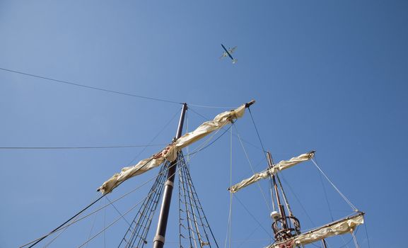 Jet pane and an old sailing ship against a summer blue sky - Croatia.