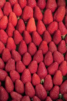 Background of ripe tasty strawberries seen on a Fench market place in April.