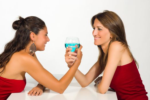 Girls toasting, one with alcohol, the other with water