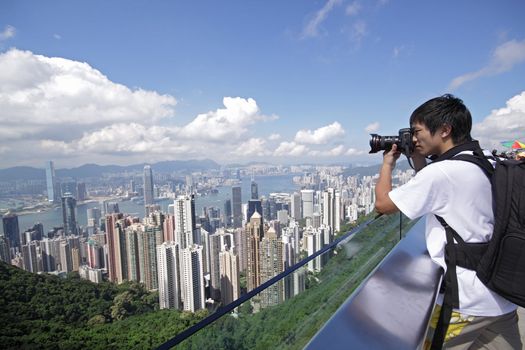 Tourist taking photo of Hong Kong skyline by his digital camera 