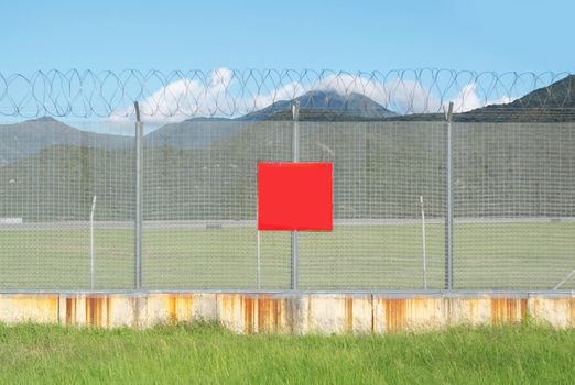 metal fence in the nature and red board for text