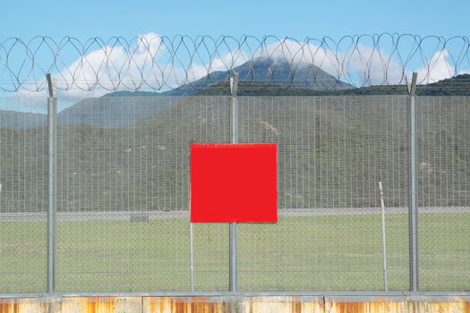 metal fence in the nature and red board for text