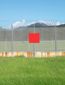 metal fence in the nature and red board for text