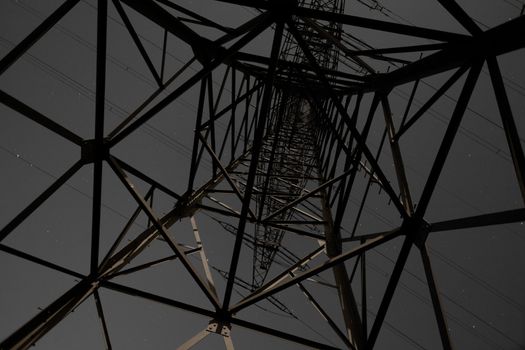 Steel structure of pylon of high voltage electric power transmission line at night.