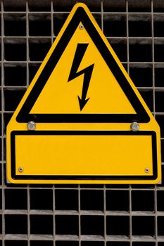 Metal high voltage danger sign bolted to steel grid with blank copyspace for your message.