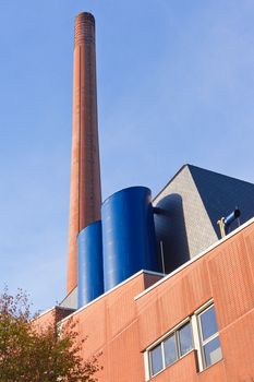 Retro designed industrial brick building with high red brick chimney.