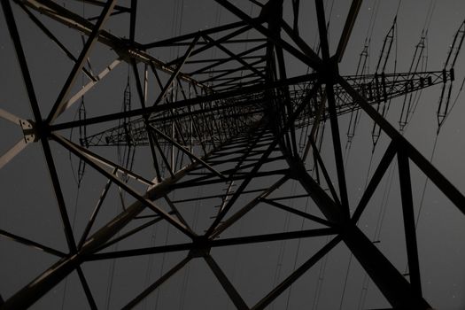 Steel structure of pylon of high voltage electric power transmission line at night.