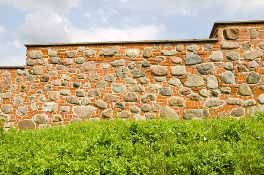 Restored ancient wall made of red brick and stones.