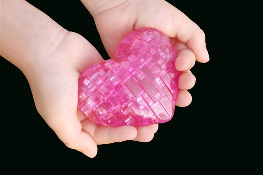 children's hands carefully holding a toy heart